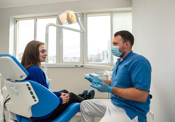 Man and woman sitting in a dentist's chair in a dental office