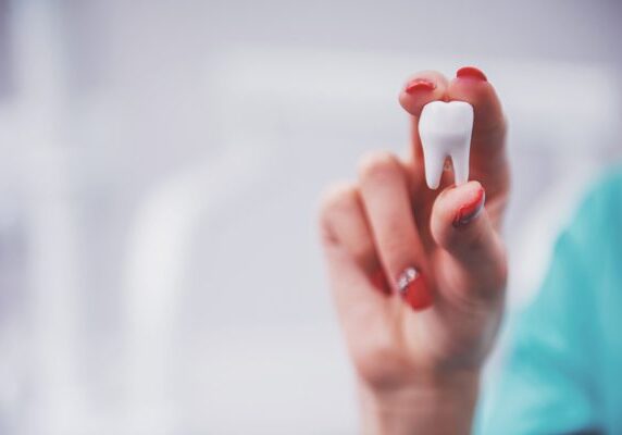 Woman holding a toothbrush in her hand, with a blurred background